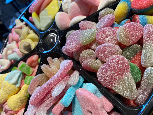 Assorted colorful gummy candies in a black tray